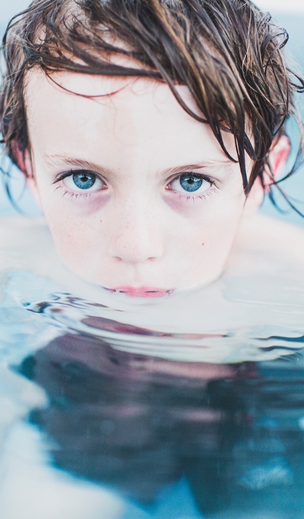 Маленький голубоглазый мальчик в бассейне