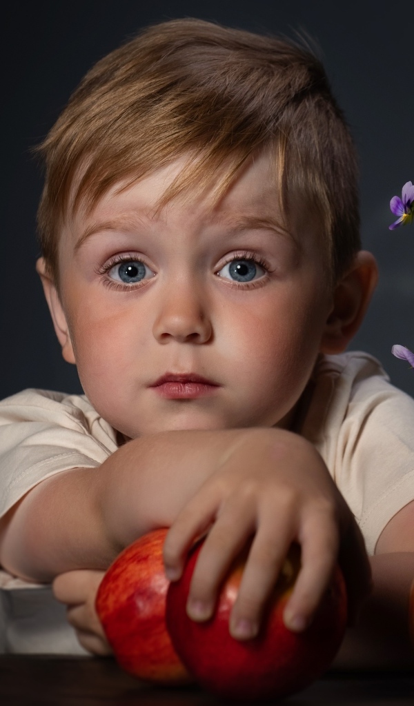 Маленький голубоглазый мальчик с яблоками