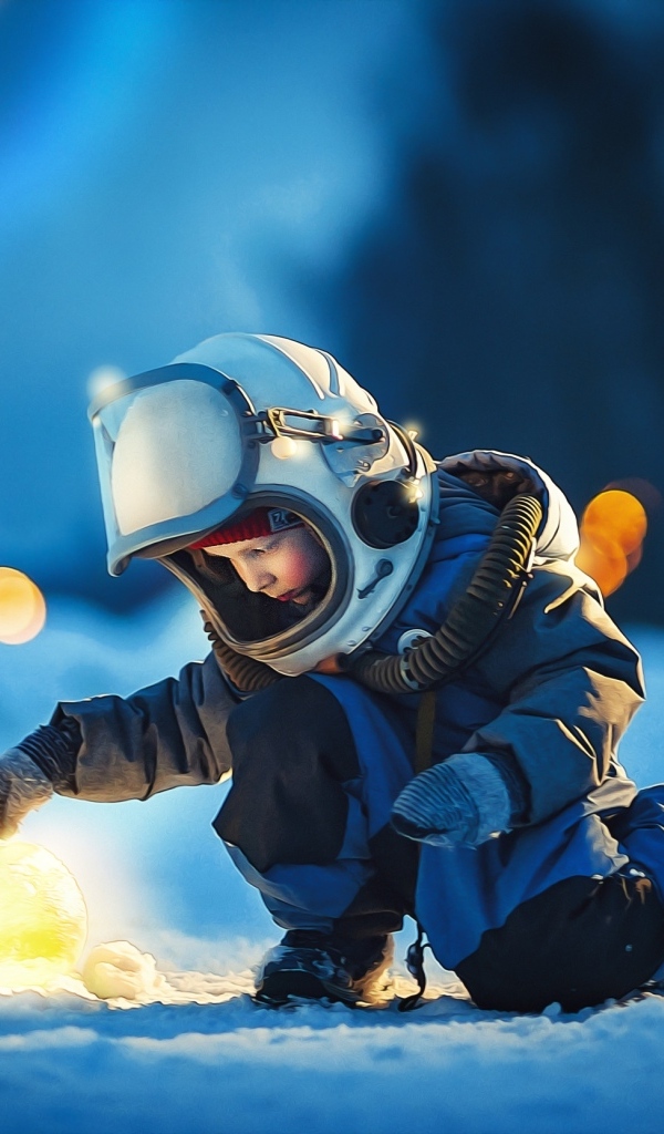 Маленький мальчик в скафандре на снегу