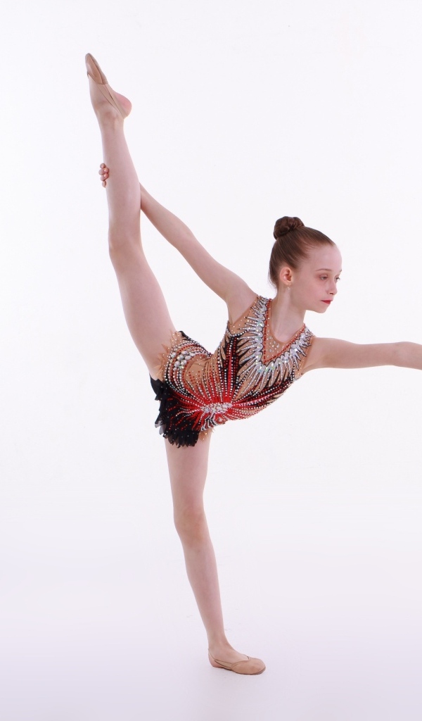 Маленькая девочка гимнастка на белом фоне