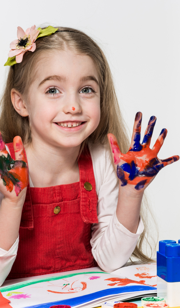 Маленькая девочка рисует красками