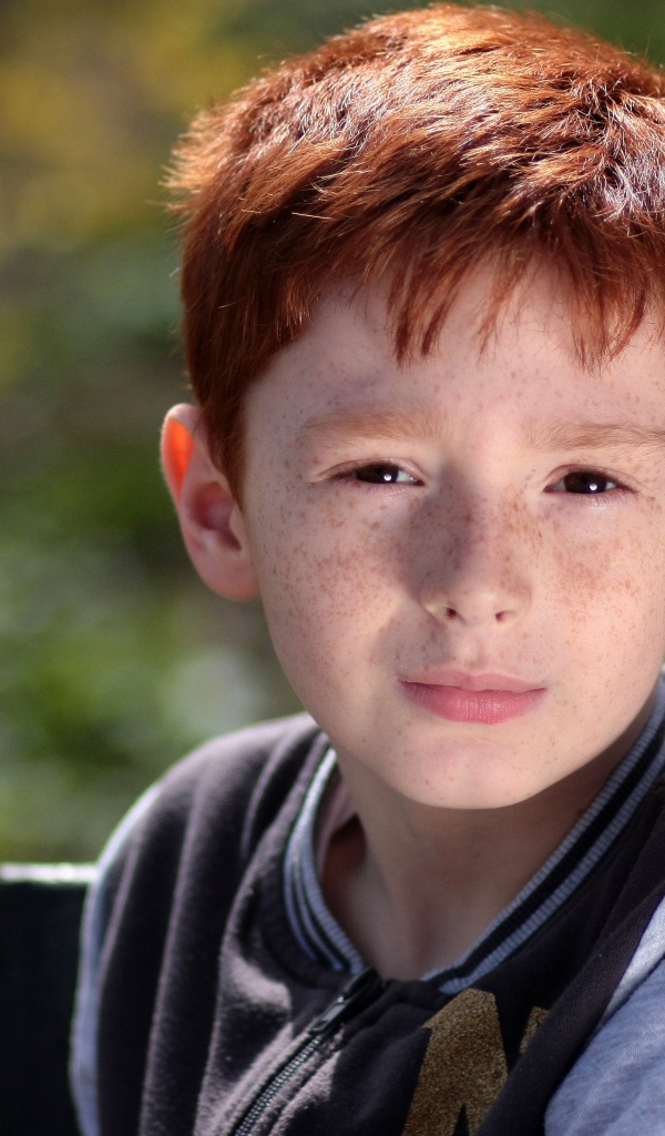 Маленький рыжеволосый мальчик с веснушками на лице