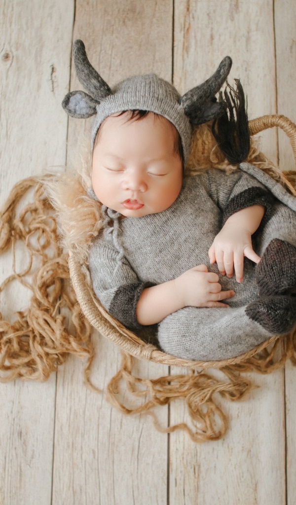 Маленький спящий ребенок в вязаном костюме