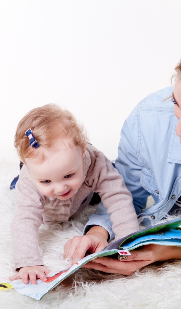 Мама читает книгу с девочкой 