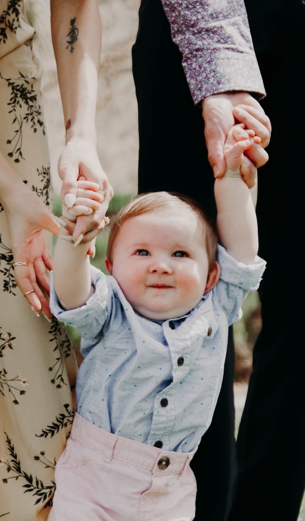 Родители ведут маленького ребенка