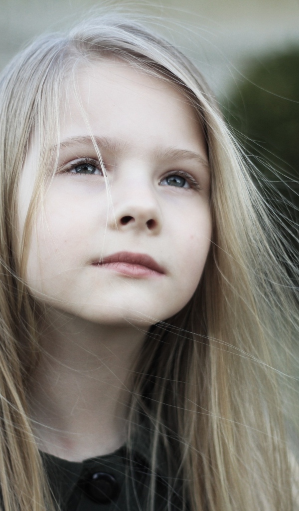 Задумчивая маленькая девочка с длинными волосами