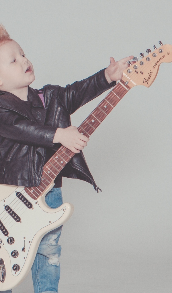 Мальчик рокер с гитарой на сером фоне