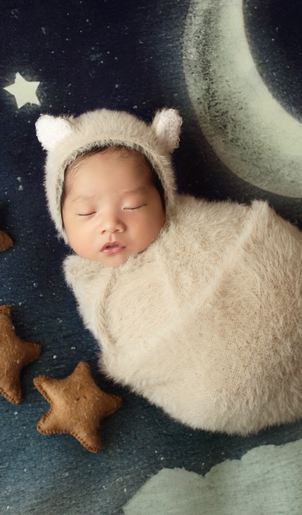 Спящий новорожденный ребенок с декором для фото 