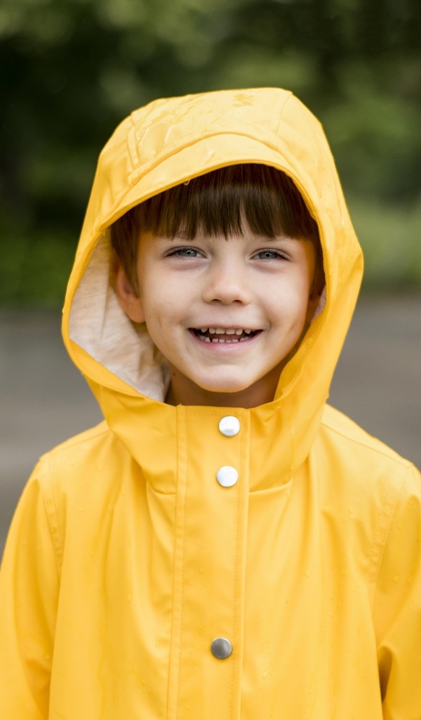 Улыбающийся мальчик в желтой куртке