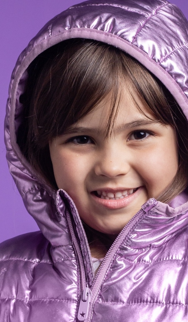 Улыбающаяся девочка в сиреневой куртке