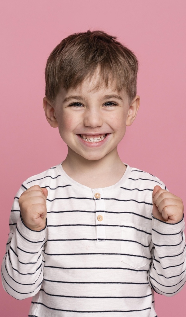 Улыбающийся маленький мальчик на сиреневом фоне