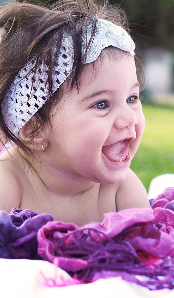 Улыбающаяся маленькая девочка с повязкой на голове 