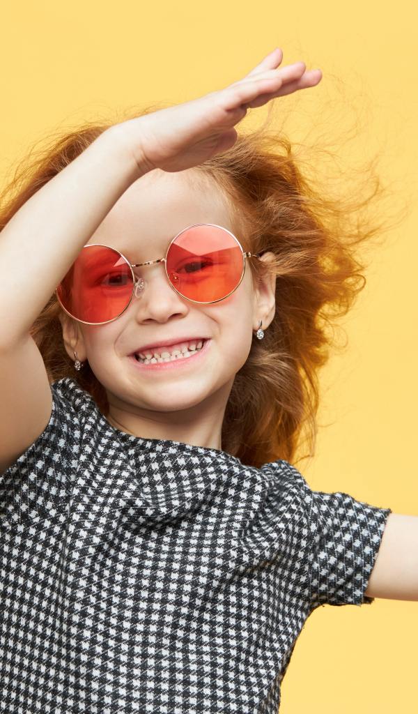 Улыбающаяся рыжеволосая девочка в очках