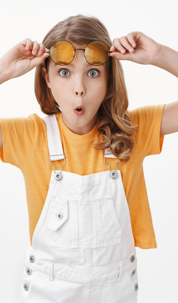 Удивленная девочка в очках на белом фоне