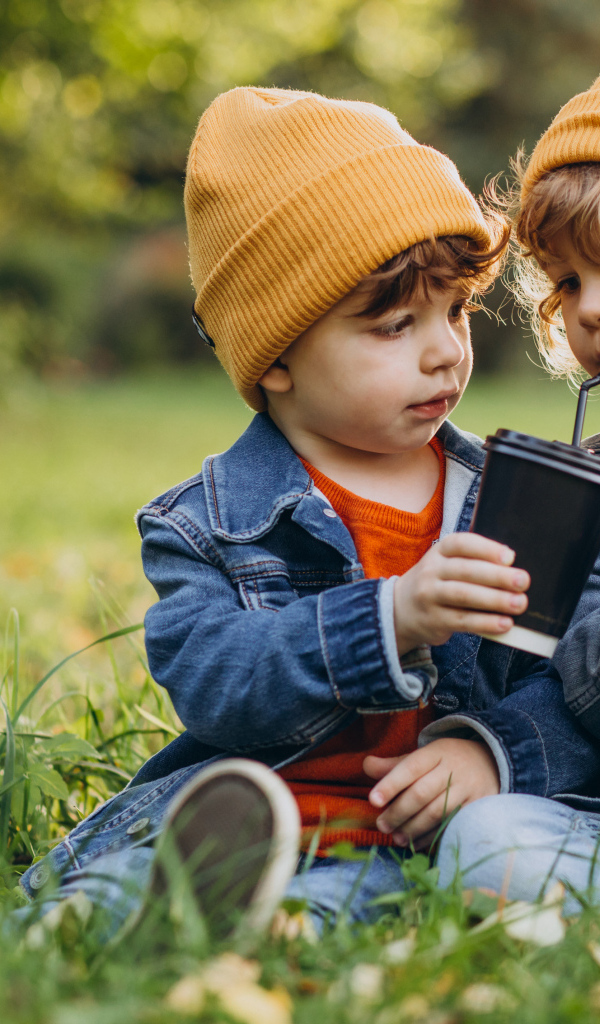 Два маленьких  брата сидят на траве