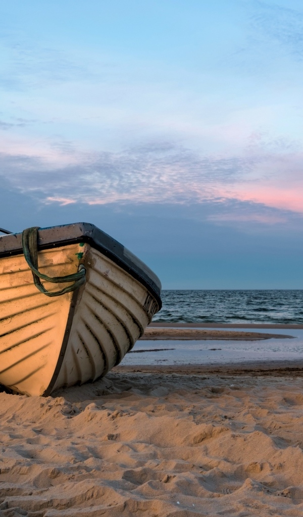 Лодка стоит на песке у моря летом