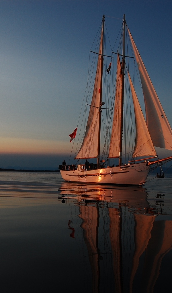 Большая парусная яхта в море на закате