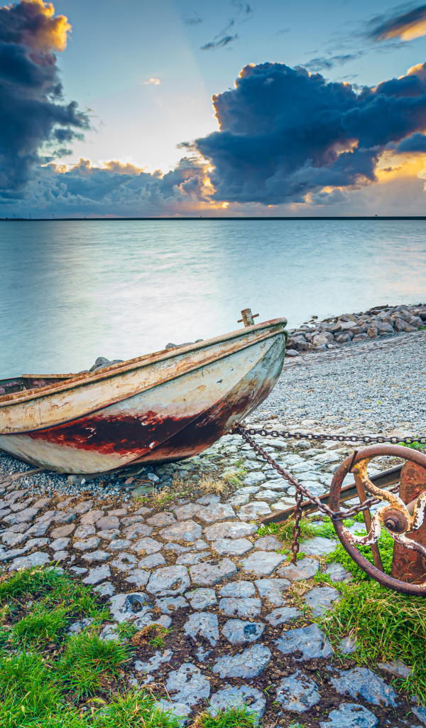 Старая лодка на берегу моря 