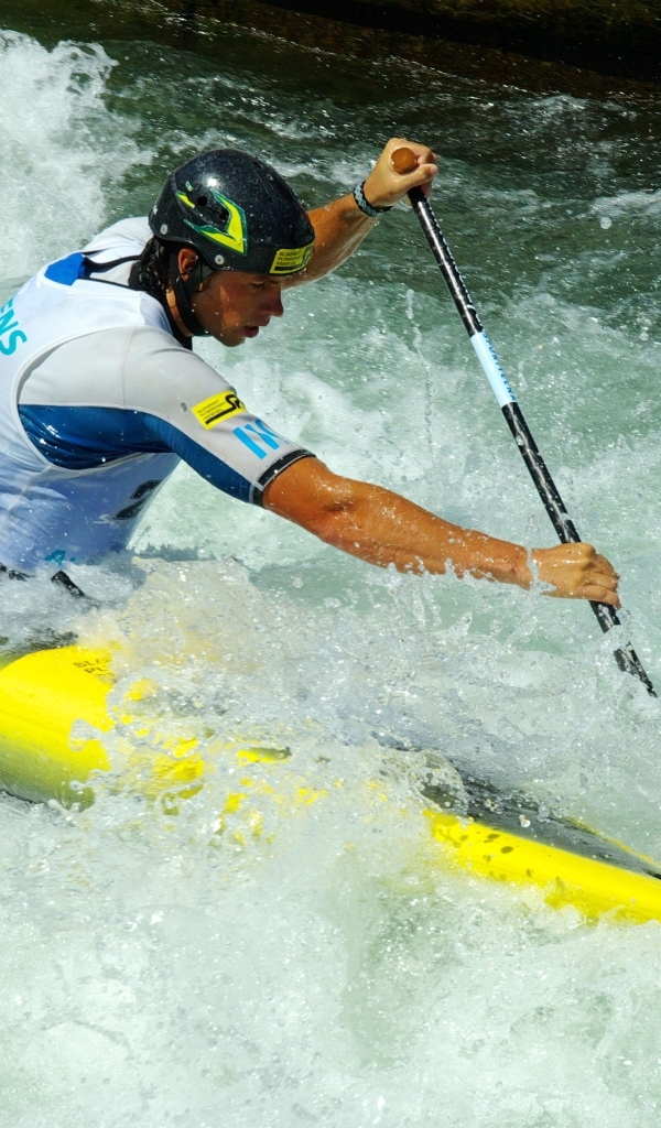 Мужчина на байдарке спускается по бурной реке