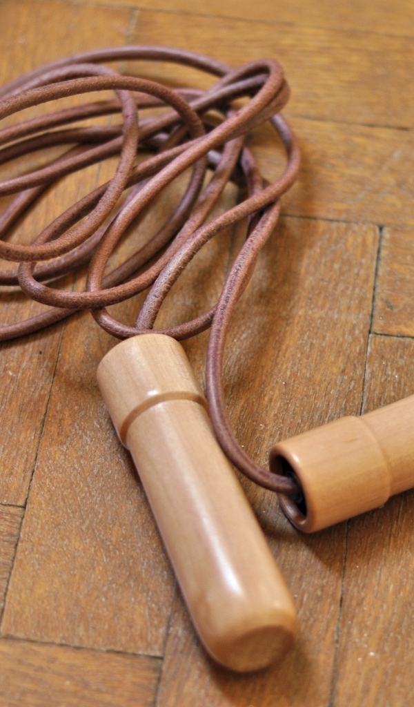 Скакалка лежит на деревянном полу