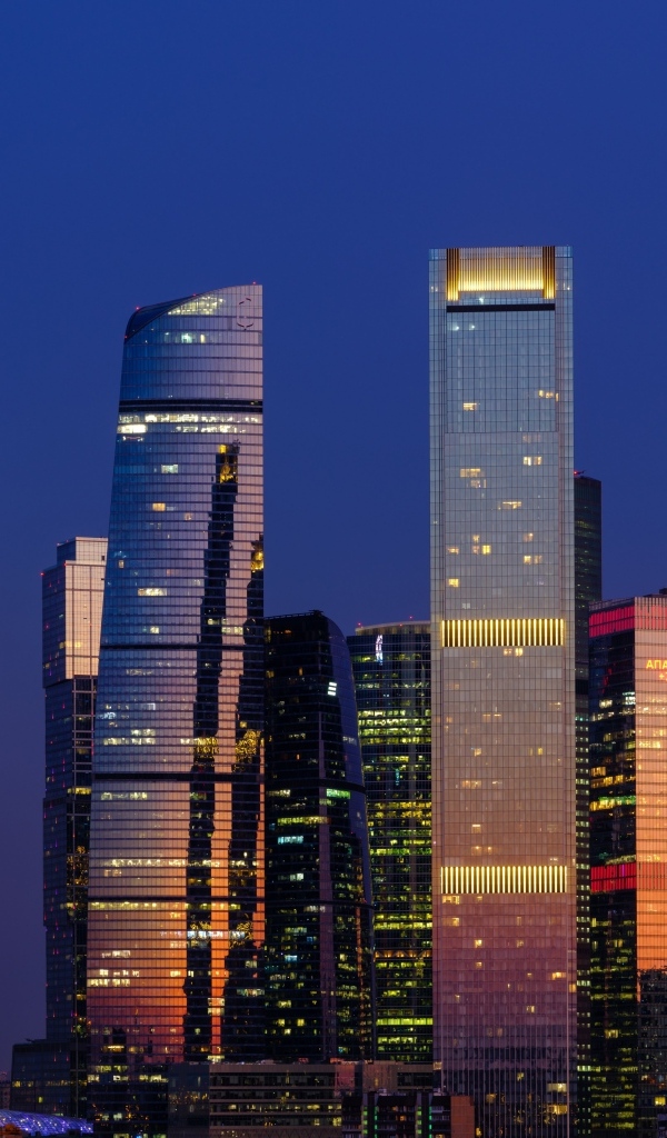 Высокие светящиеся небоскребы Москвы в сумерках, Россия