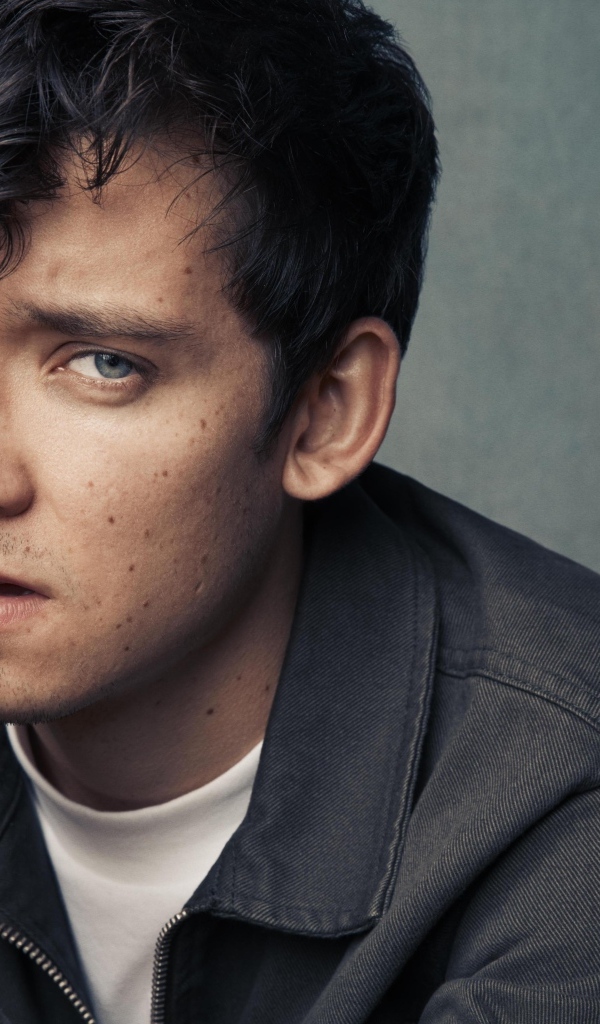 Актер Эйса Баттерфилд на сером фоне