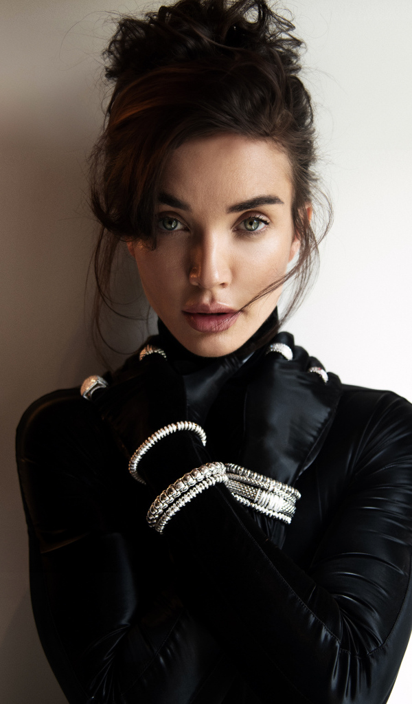 Актриса Эми Джексон стоит у стены