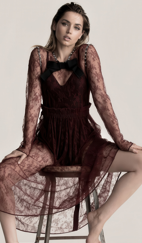 Актриса Ана де Армас в прозрачном платье сидит на стуле