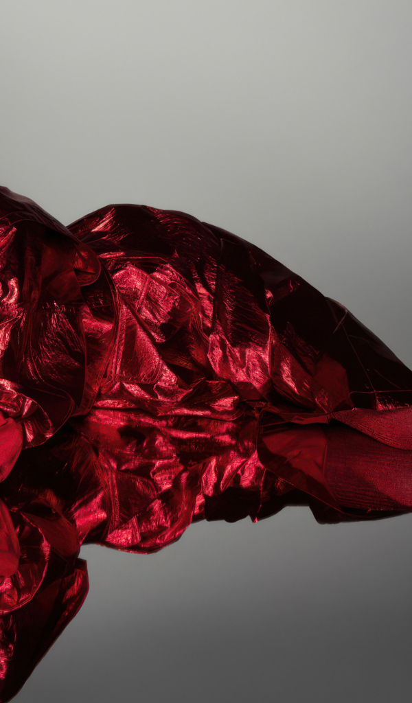 Актриса Анна Кендрик в красном костюме на сером фоне