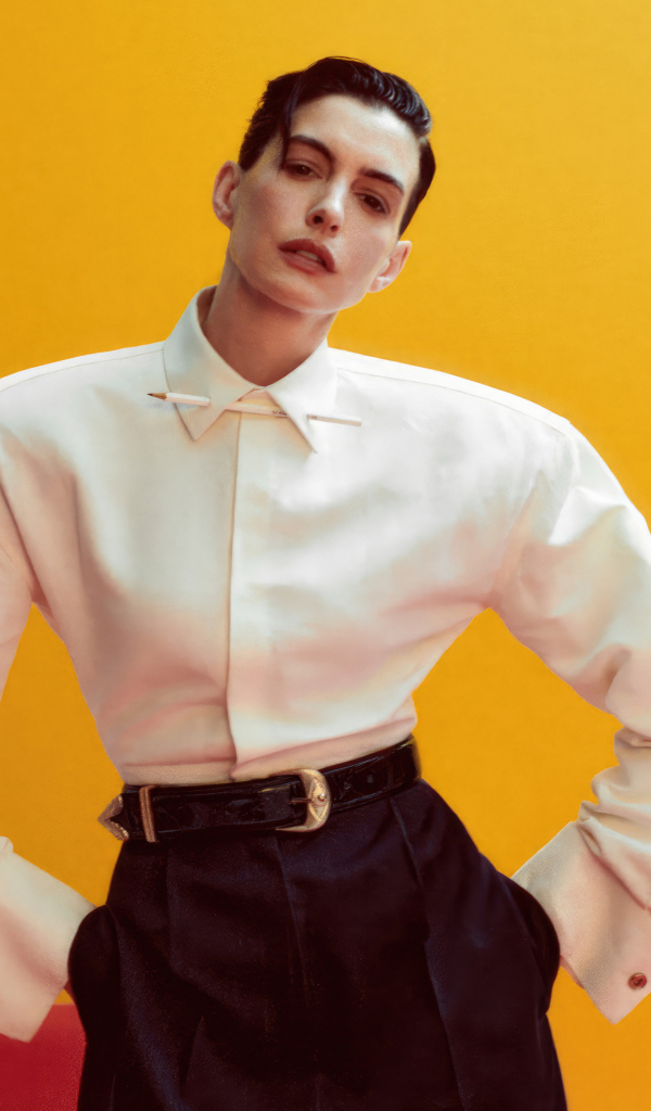 Актриса Энн Хэтэуэй в белой рубашке на желтом фоне