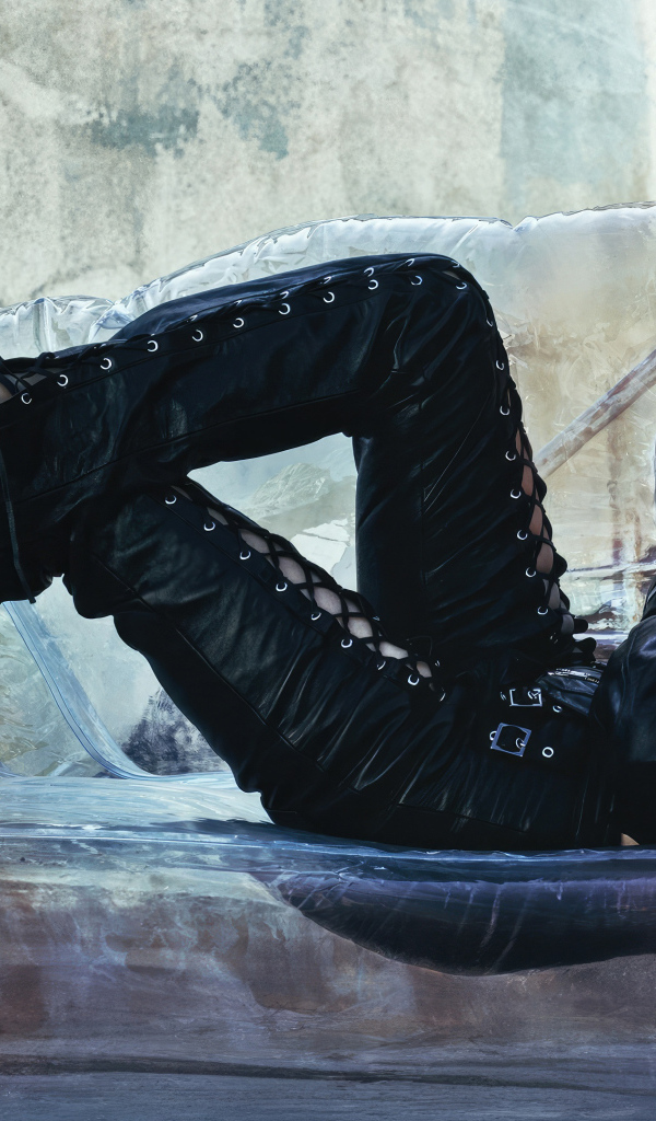 Актриса Аня Тейлор-Джой в черном костюме лежит на диване