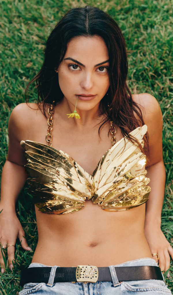 Актриса Камила Мендес лежит на зеленой траве