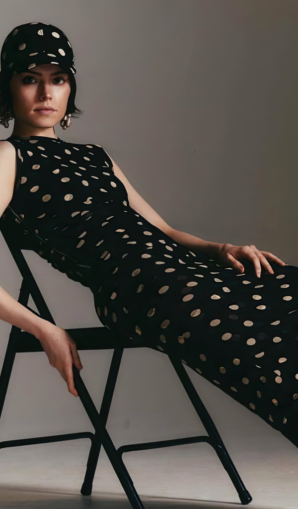 Актриса Дейзи Ридли в черном платье сидит на стуле