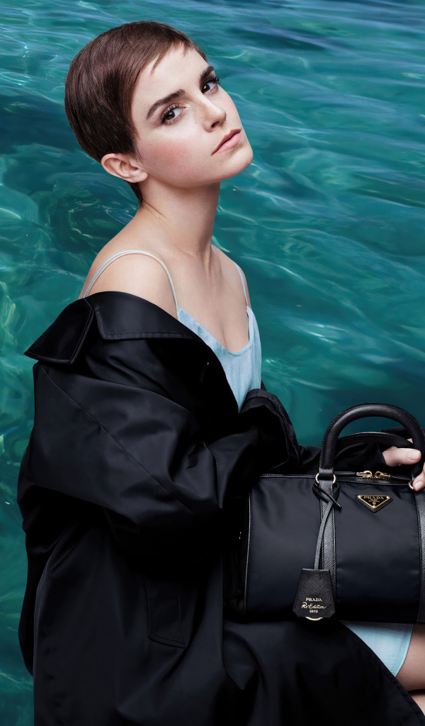 Актриса Эмма Уотсон с сумочкой сидит у воды