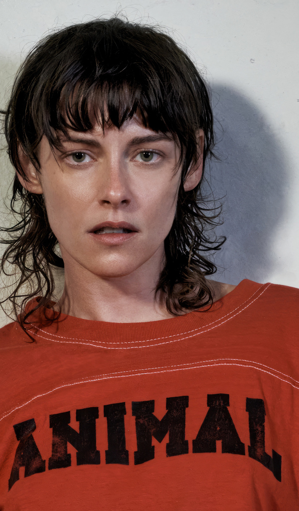 Актриса Кристен Стюарт стоит у серой стены