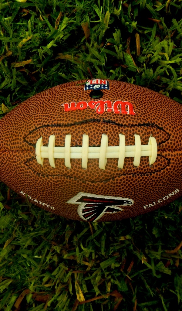 Мяч для игры в американский футбол на зеленой траве