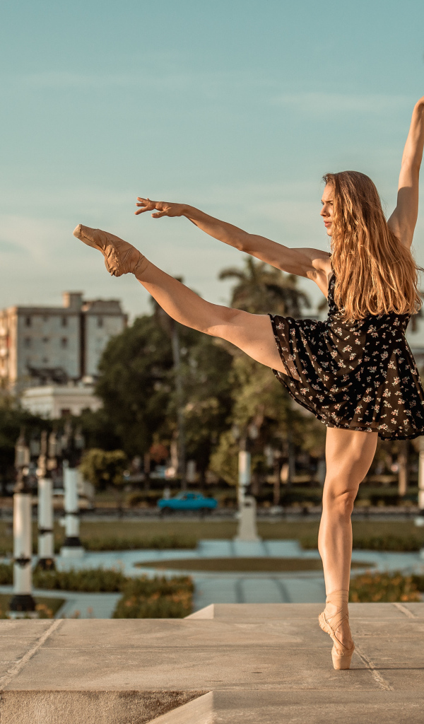 Балерина в лучах солнца у стены