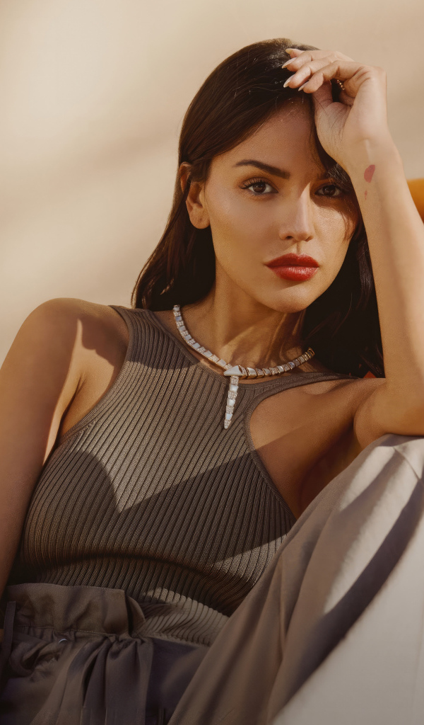 Красивая брюнетка, актриса Эйса Гонсалес сидит у дивана