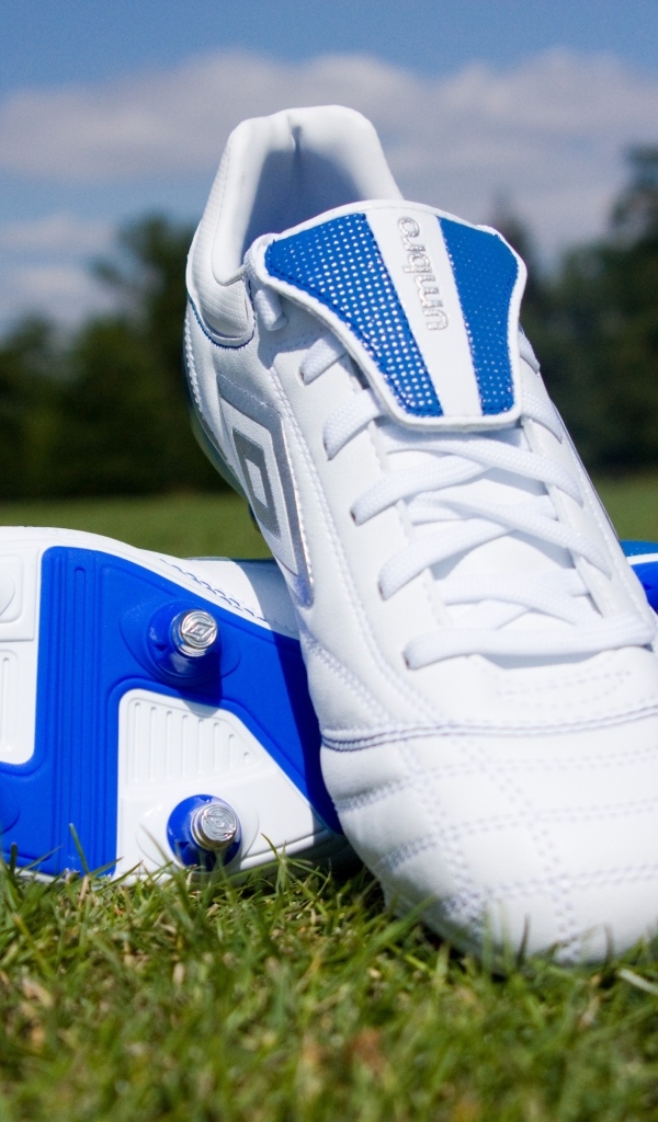 Красивые новые футбольные бутсы на зеленой траве 