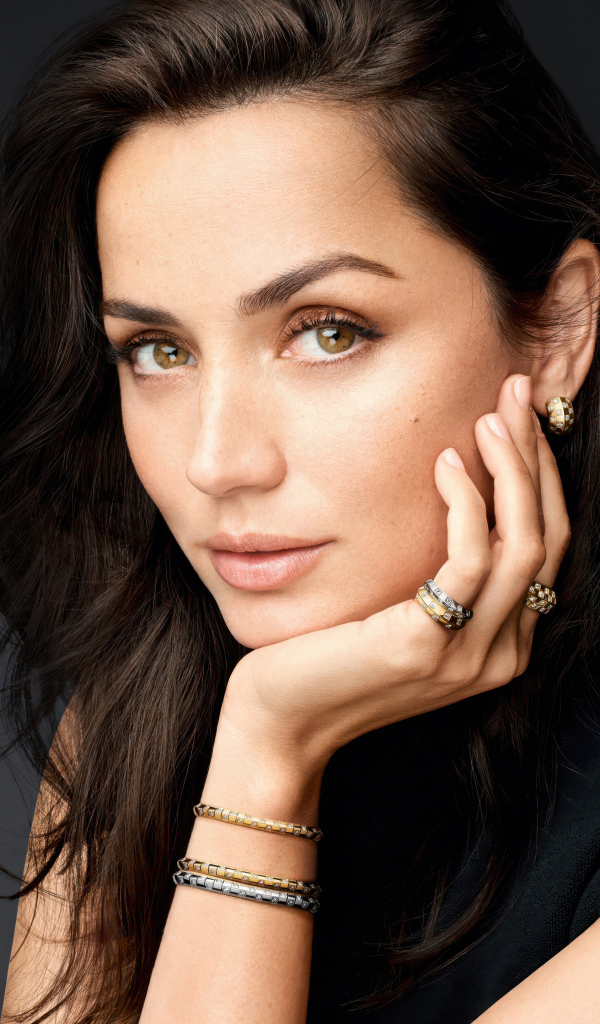 Кареглазая девушка актриса Ана де Армас на сером фоне