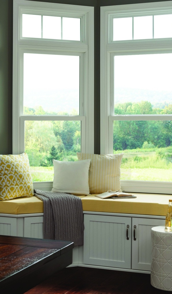 Уютная светлая кухня с эркером в загородном доме в зеленых тонах