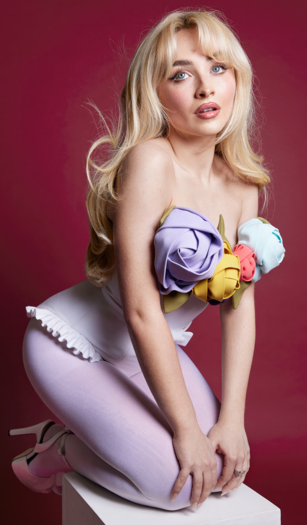 Милая девушка актриса Сабрина Карпентер на красном фоне