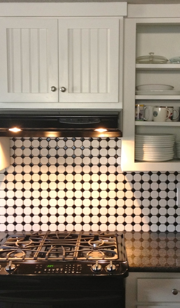 Электрическая плита в кухне с белым гарнитуром