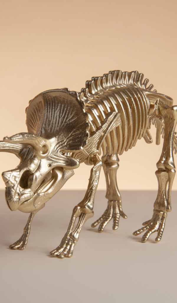 Золотой скелет динозавра на коричневом фоне