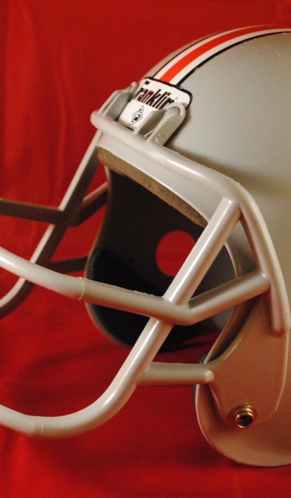 Шлем для игры в американский футбол на красном фоне