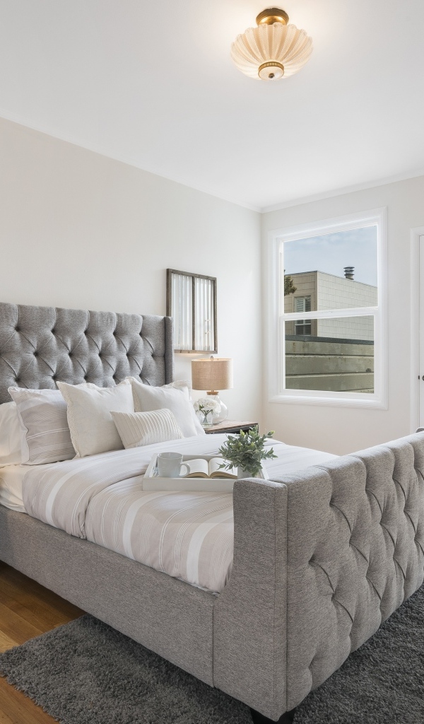 Высокая серая кровать в спальной комнате