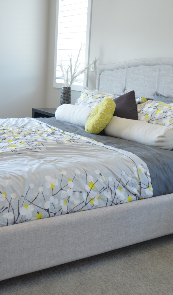 Большая мягкая кровать в серой спальне