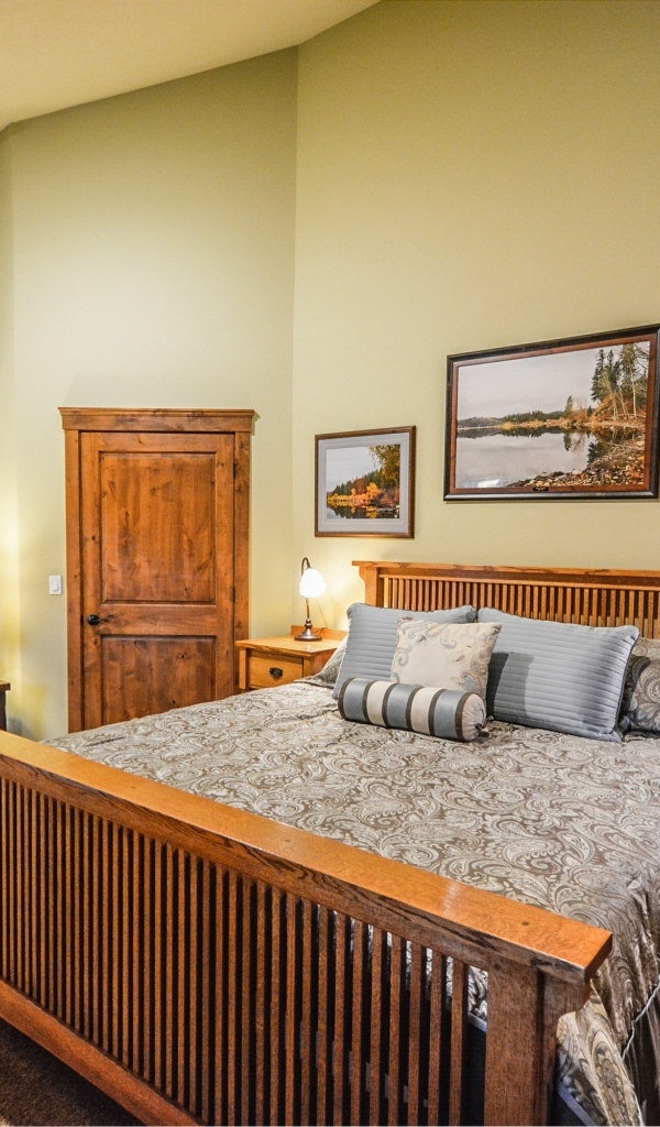 Большая деревянная двуспальная кровать в комнате