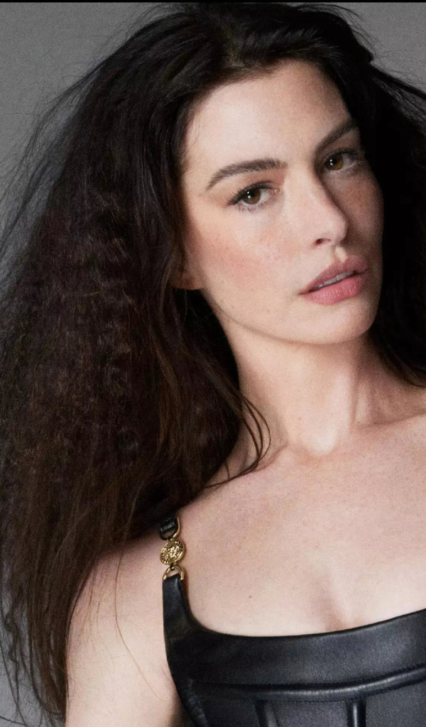 Длинноволосая актриса Энн Хэтэуэй на сером фоне