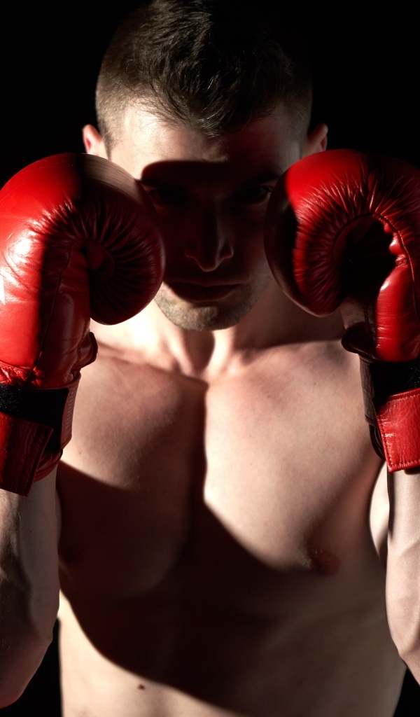 Мужчина в стойке в красных боксерских перчатках 